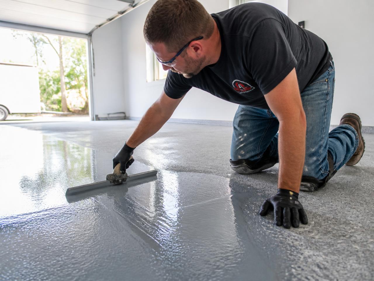 Professional installer applying premium epoxy coating to a New Jersey garage floor